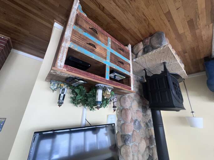 Cozy up by your stone fireplace beneath rustic wood ceiling beams and exposed brick details.