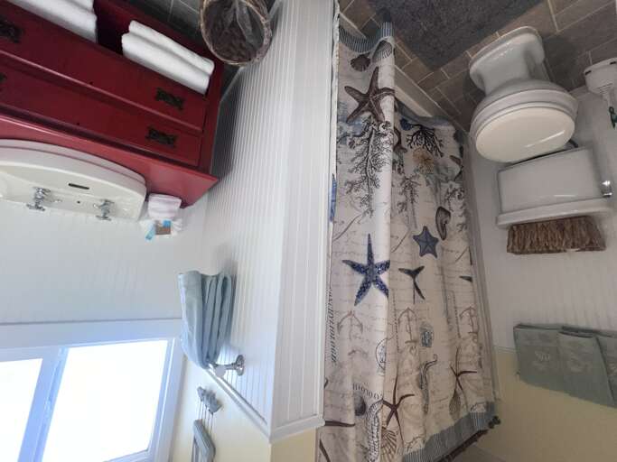 Your nautical-themed downstairs bathroom features a relaxing shower with ocean-inspired dÃ©cor and coastal charm throughout.