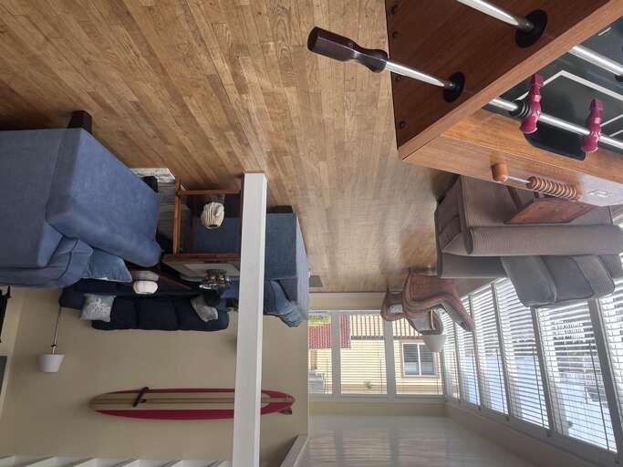 Relax in your cozy living space with comfortable seating, warm wood ceilings, and natural light streaming through the windows.