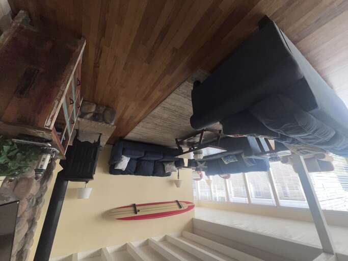 Relax in your rustic living space with exposed wooden beams and cozy seating. The large windows fill your retreat with natural light.