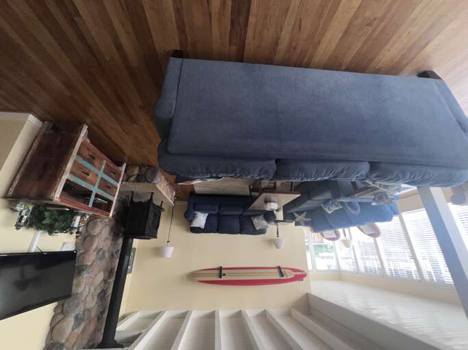 Sink into plush seating beneath stunning wood beams while your surfboard awaits the next adventure. This cozy retreat blends rustic charm with coastal style.