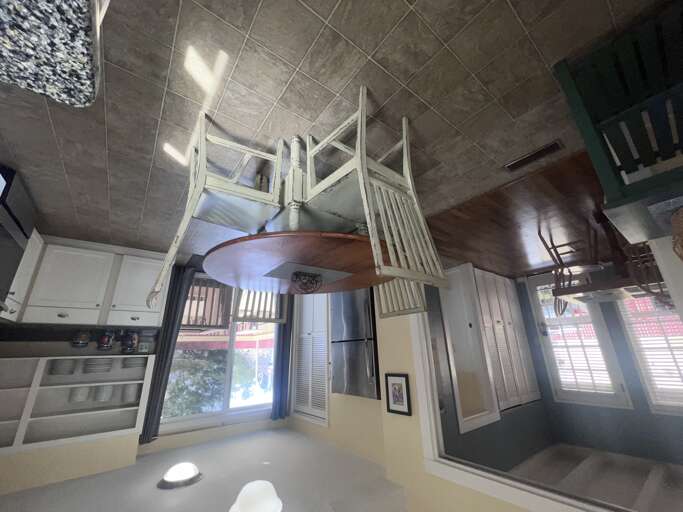 Step into your unique loft-style retreat with spiral stairs leading to a cozy elevated sleeping area, complete with modern kitchen amenities below.