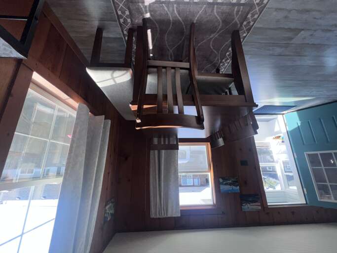 Gather around the wooden dining table where morning coffee and evening meals become cherished memories, with natural light streaming through nearby windows to brighten your stay.