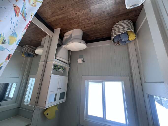 Your private bathroom features clean lines, coastal charm, and a cozy wood-paneled ceiling that adds warmth to your space.