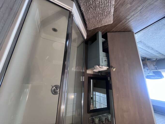 Step into your modern bathroom with a sleek glass-enclosed shower, contemporary vanity, and warm wood-grain finishes that create a comfortable spa-like retreat.