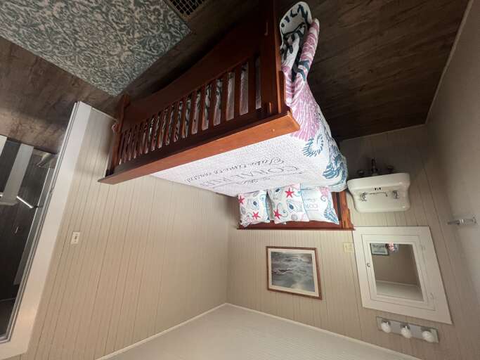 Settle into your private bedroom with cheerful coastal linens and a cozy nautical vibe, where a built-in loft adds extra sleeping space for family or friends.