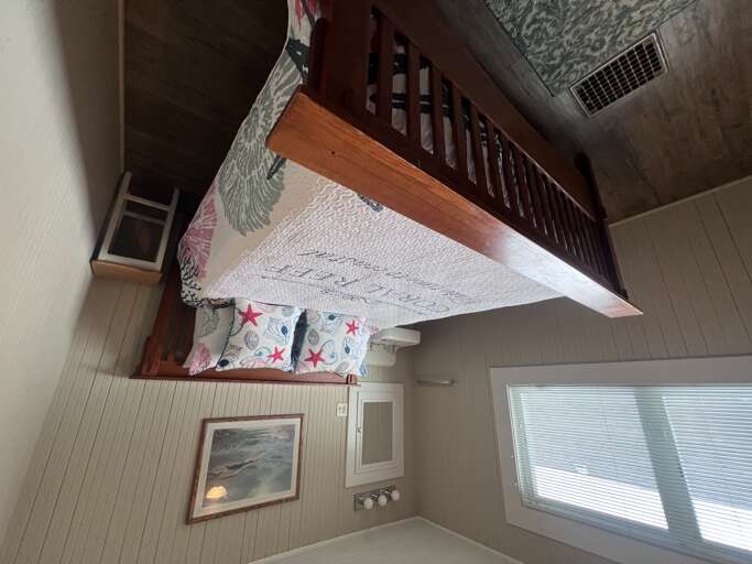 Drift off in this peaceful bedroom where a classic wooden bunk bed and cheerful coastal linens make your stay feel just like home.