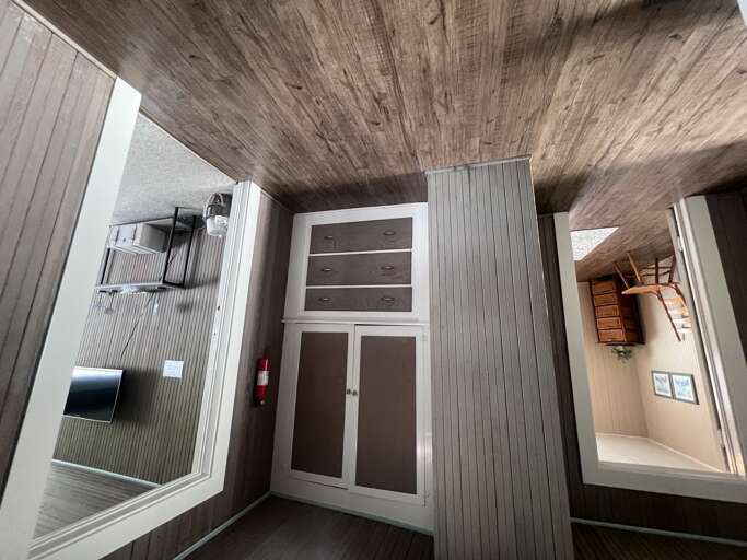Look up and admire the striking wood-paneled ceiling, adding rustic warmth to your stay. Built-in storage keeps your space tidy, while thoughtful touches like open shelving create a cozy, home-away-from-home feel.