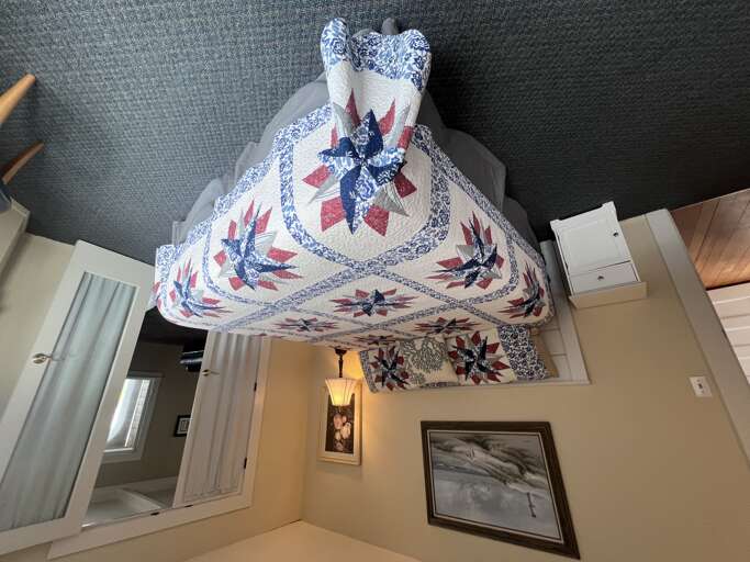 Your cozy retreat awaits with a beautifully quilted bed that promises restful nights and peaceful mornings in this charming space.