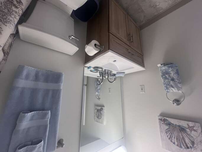 Your private bathroom features a sleek modern design with a bright sink, convenient storage, and fresh towels—everything you need to feel right at home during your stay.