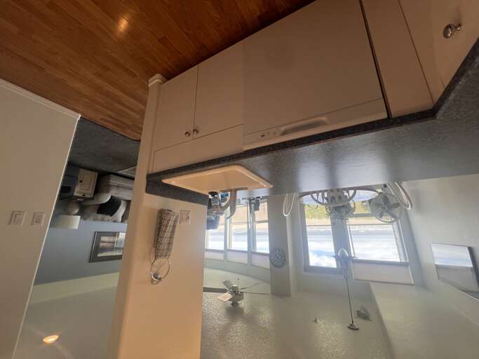 Your compact kitchen features modern white cabinetry, stainless backsplash, and a cozy breakfast bar perfect for casual meals and coffee in the morning.
