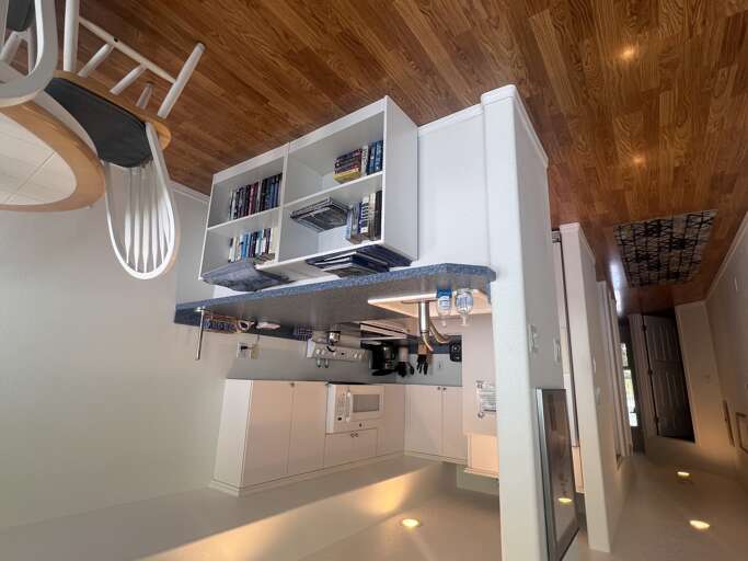 Cook, gather, and unwind in your beautifully designed kitchen featuring sleek white cabinetry, stainless steel appliances, and a spacious breakfast bar under warm wooden ceilings.