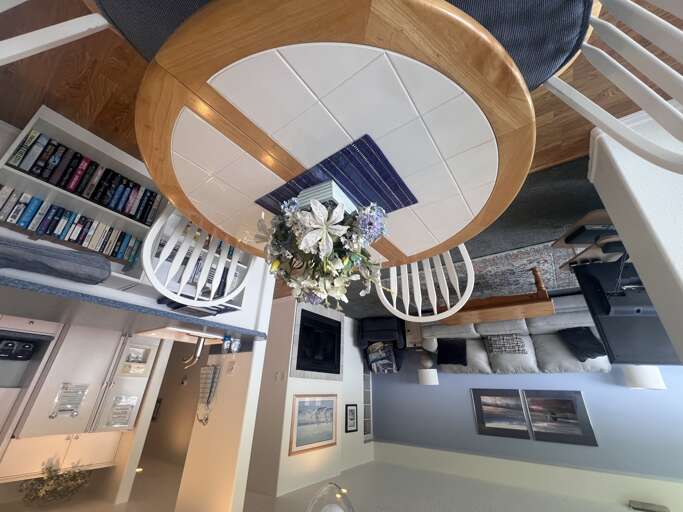 Looking down from above, discover the cozy circular dining nook where you'll gather for meals surrounded by coastal charm and thoughtful details throughout your stay.