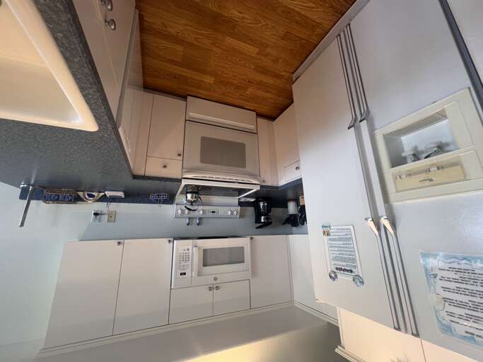 Your kitchenette comes fully equipped with everything you needâmicrowave, stove, and fridgeâset beneath a warm wood-paneled ceiling that adds cozy charm to your home-away-from-home.
