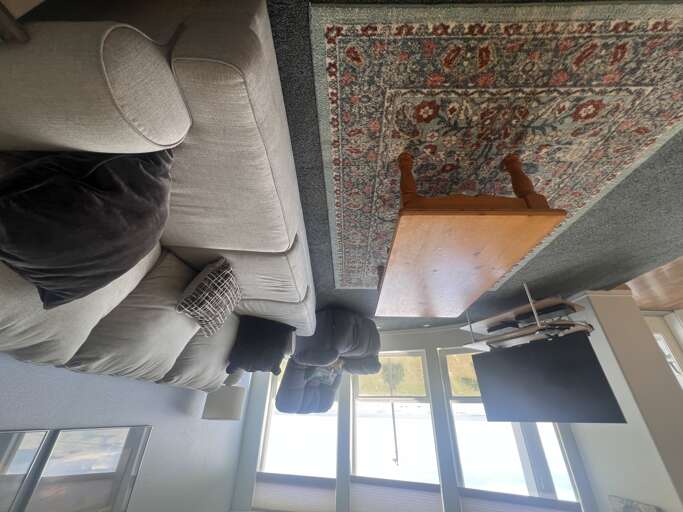 Relax in your bright living area with plush seating, a warm patterned rug, and modern touchesâperfect for unwinding after a day of exploring.