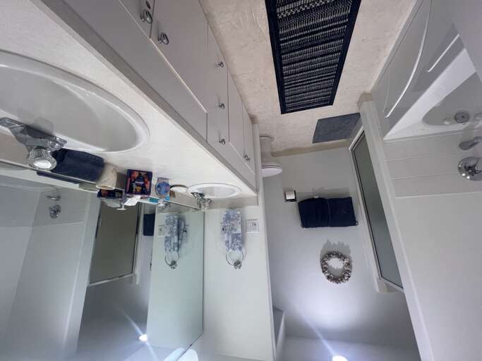 Step into your pristine, bright bathroom with twin sinks, a spacious walk-in shower, and modern white cabinetryâeverything you need to refresh and unwind in style.