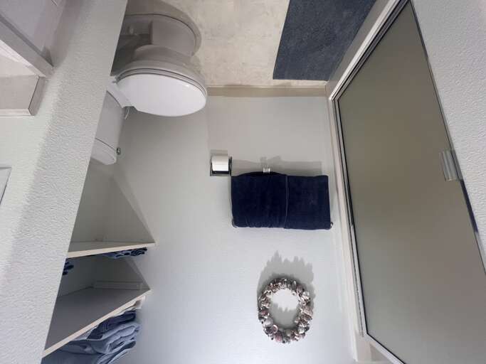 Step into your private bathroom featuring modern fixtures, plush towels, and a refreshing shower. The crisp white design and thoughtful amenities create a spa-like retreat for your stay.