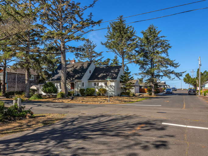 Charming coastal property nestled among mature evergreens in a peaceful seaside neighborhood, offering easy access to local beaches and attractions.