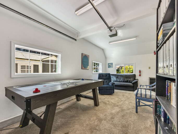 Challenge a friend to a friendly air hockey match in your bright, dedicated game room with comfortable lounge seating for spectators.
