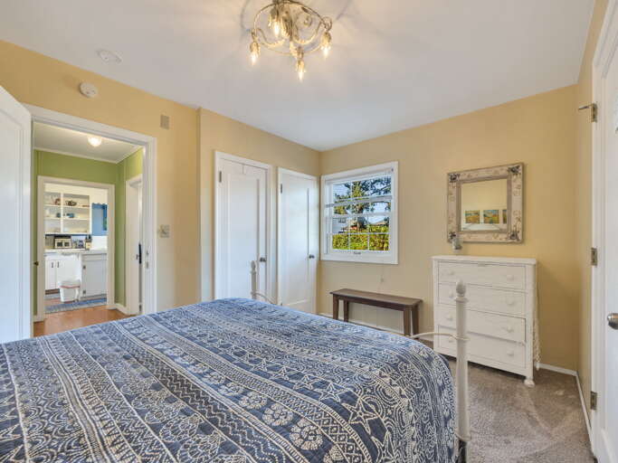 Peaceful bedroom with soft morning light, rustic charm, and modern comfort. Featuring a plush bed, vintage dresser, and surrounding views—perfect for restful nights and lazy mornings.