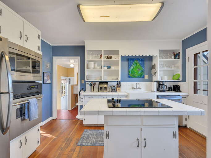 Cook your favorite meals in this bright, fully equipped kitchen with modern appliances, ample counter space, and charming details that make you feel right at home.
