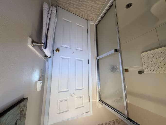 Step into your private bathroom, where fresh towels await and a glass-enclosed shower offers a peaceful retreat after a day of adventure.