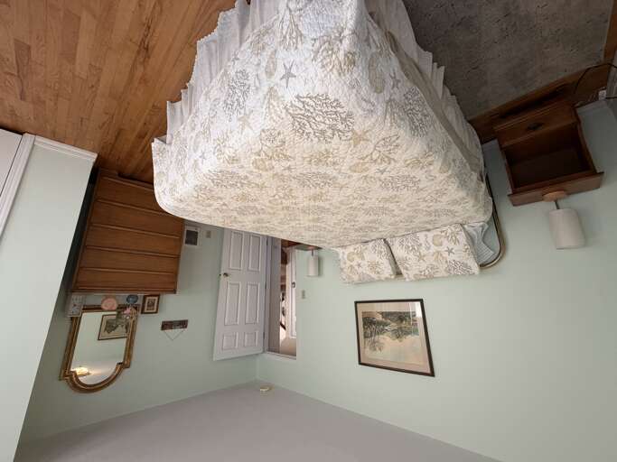 Sink into crisp linens and timeless charm in your cozy bedroom retreat, where wood ceilings and classic touches create a warm, inviting atmosphere for restful nights.