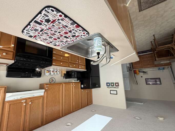 Your fully equipped kitchen awaits, complete with a range hood, microwave, and charming oak cabinetry. Ready to whip up a home-cooked meal or enjoy your morning coffee?