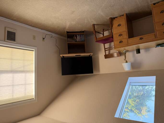 Climb into your cozy loft space, complete with storage cubbies and a flat-screen TV for winding down after a day of adventure. Natural light fills the room, creating a warm, inviting retreat.