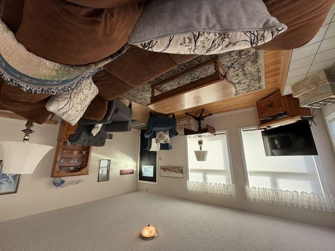 Step into your cozy living space, where earthy tones and rustic wood accents create a warm retreat. Sink into the plush seating, unwind by natural light streaming through the windows, and feel at home in this inviting room.