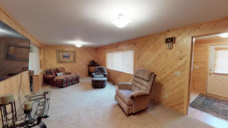 Cozy Wooden-paneled Living Room With Furniture And Carpet Flooring Cozy Wooden-paneled Living Room With Furniture And Carpet Flooring