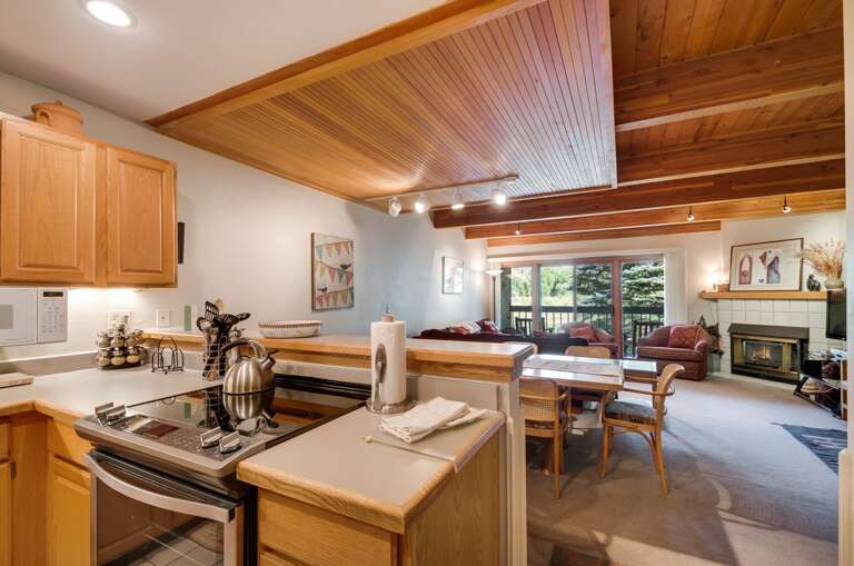 Kitchen to living area view with wood paneling and ceiling Kitchen to living area view with wood paneling and ceiling