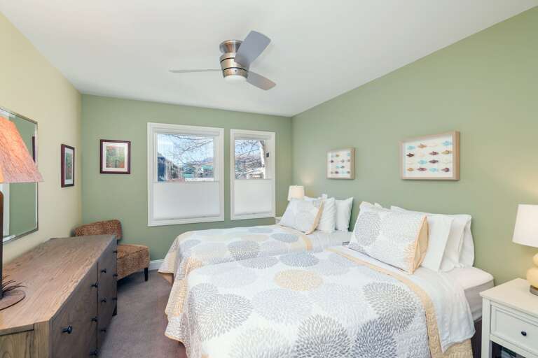 Bedroom with Two Beds, Dresser, Ceiling Fan, and Chair