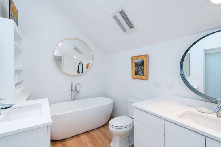Bathroom with Soaking Tub and Vanity with Round Mirror