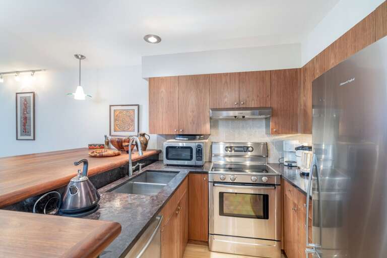 Kitchen with oven, fridge and microwave.