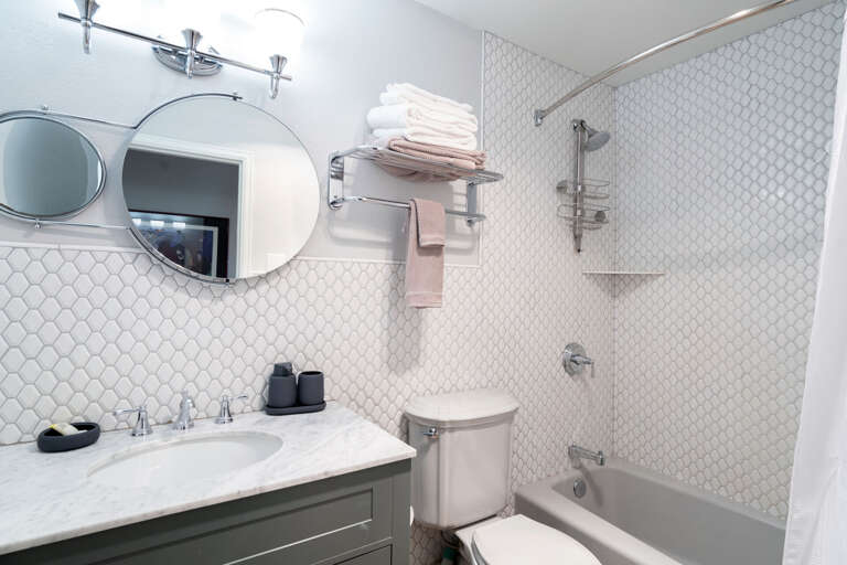 A shower/tub, a sink and towels