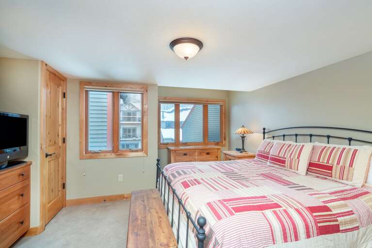 Bedroom with large bed and TV on a dresser.