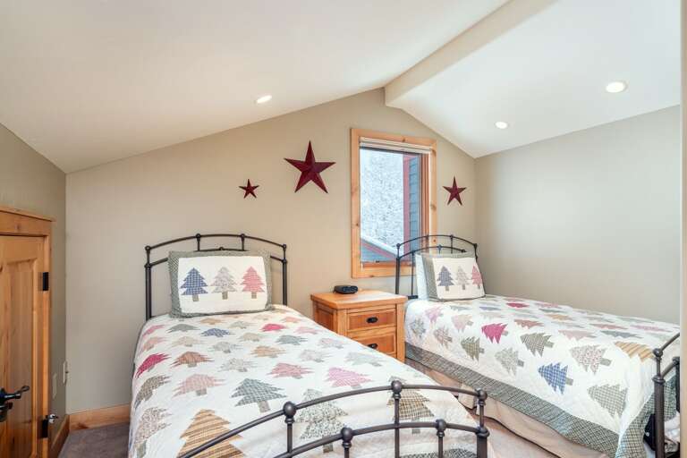 Twin beds with a nightstand in between in the second bathroom.