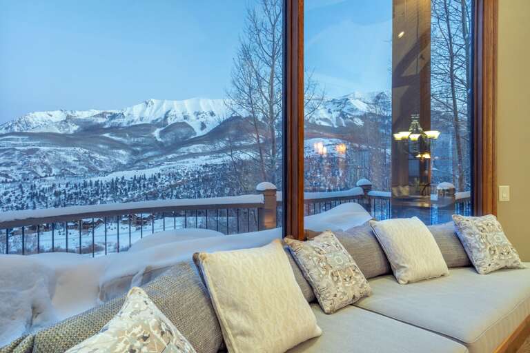Large windows behind a long cushioned bench look out onto a snowy landscape. Large windows behind a long cushioned bench look out onto a snowy landscape.