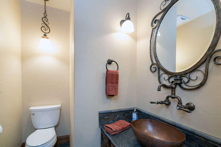 Vanity sink with unique mirror by a toilet. Vanity sink with unique mirror by a toilet.