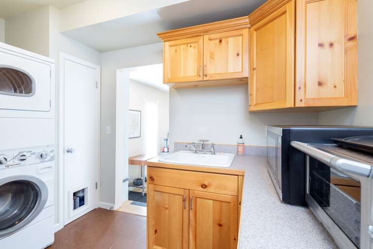Laundry room with washer, dryer, sink, microwave, and toaster oven.