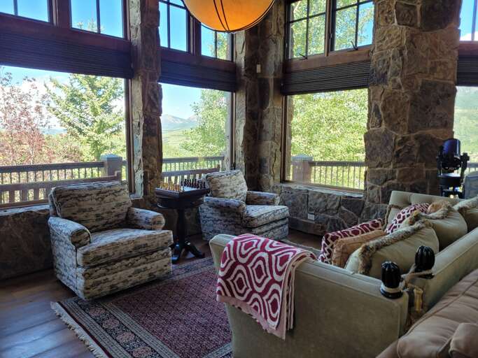 Living room with couch and two chairs and large windows