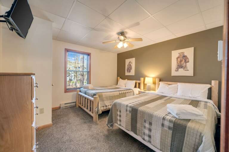 1st Floor Bedroom 1 with 2 Full Beds, Storage & TV.