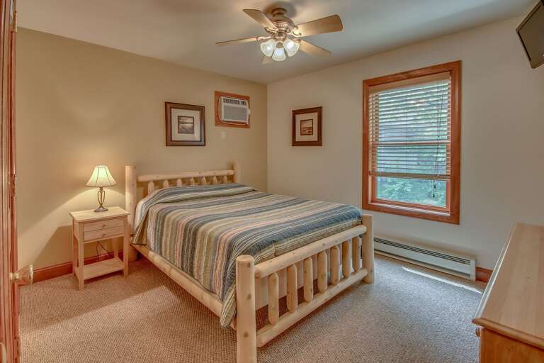 Bedroom with One Bed, Nightstand, Drawer Chest, Ceiling Fan, and TV.