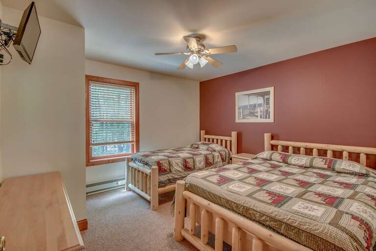 Bedroom with Two Beds, Ceiling Fan, a Drawer Chest, and TV.
