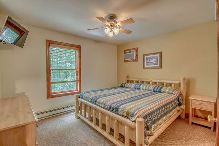 Bedroom with a Large Bed, Drawer Chest, Nightstand, and TV.