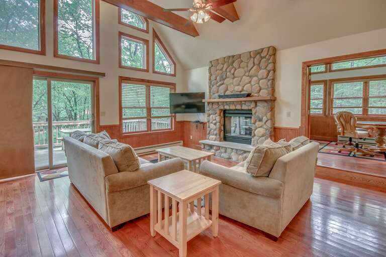 Living Room Area with Two Couches, Side Table, Coffee Table, TV, and Fireplace.