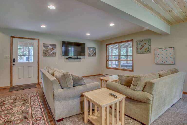 basement room with two couches and a TV