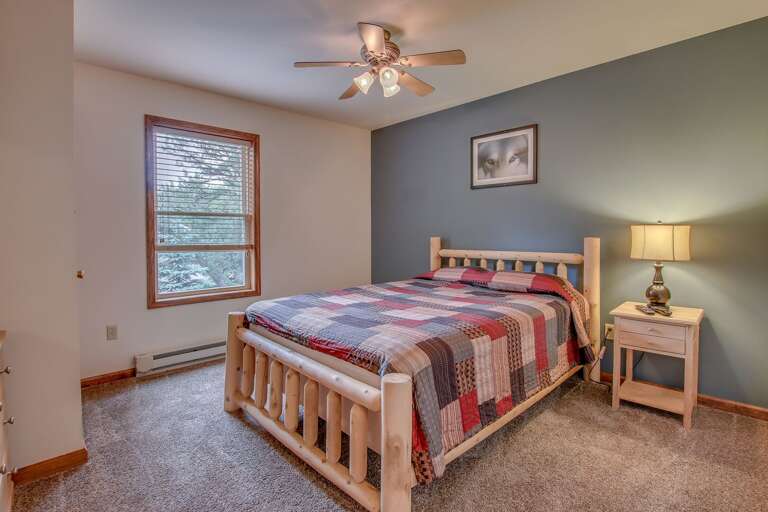 single bed in blue bedroom with nearby ceiling fan