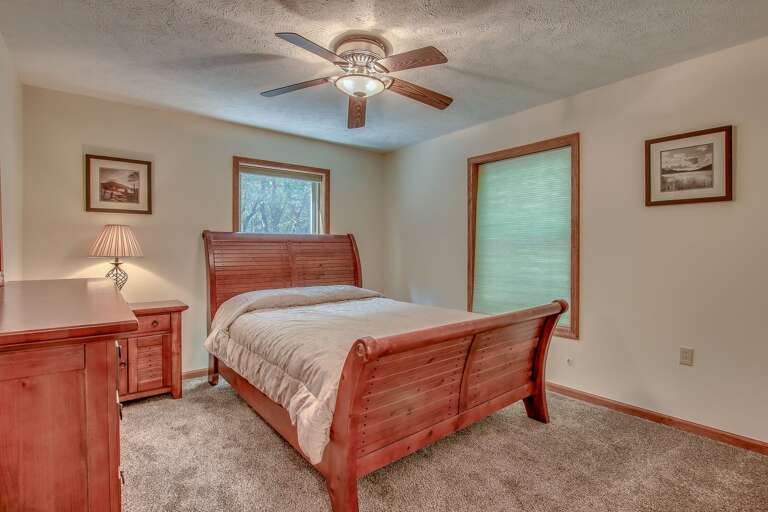 Bed in the center of a bedroom, with a nightstand and dresser to the right, a window to the left. Bed in the center of a bedroom, with a nightstand and dresser to the right, a window to the left.